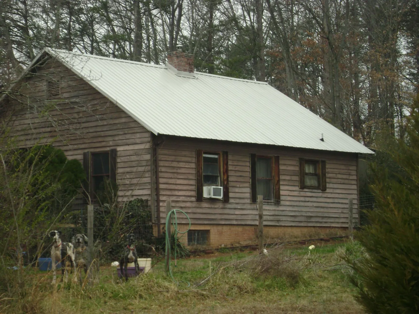 White metal roof on an old wood sided farmhouse, from a Metal Roof Installation job in Brooks